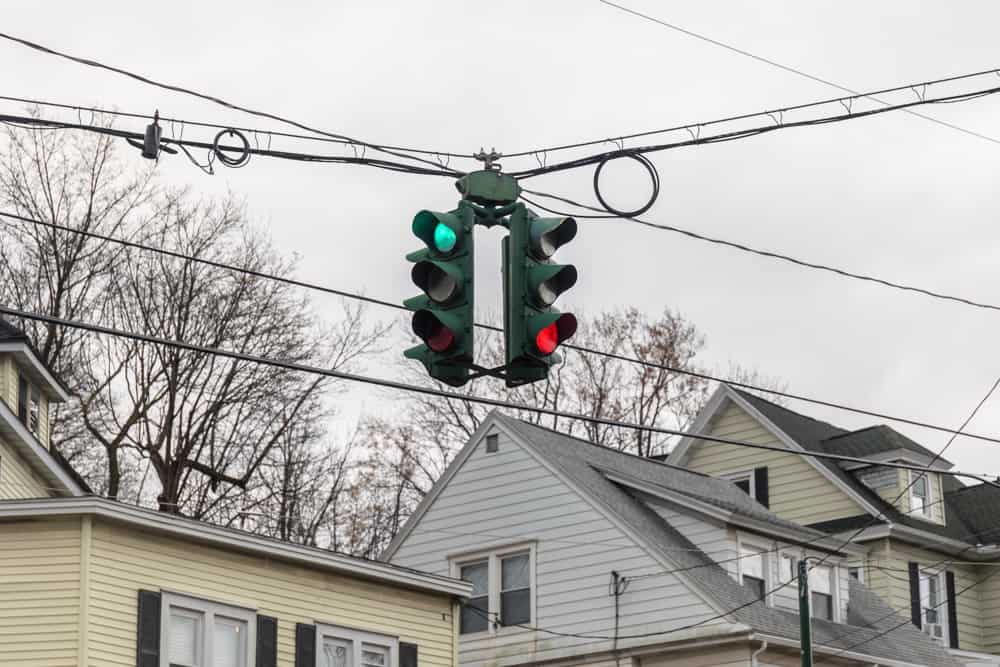 An unusual traffic light where the order of the red, yellow, and green lights is reversed.